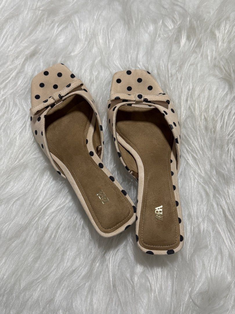ZARA Beige Polka Dot Mule w Bow (Category: Flats & Sandals) located in Subic. Submitted by juls_mp (Listing ID 1468372223, Image 1). Description: - Brand: ZARA - Style: Slip-on slide sandals - Design: Beige with black polka dots, square toe, and tiny front bow - Details: Suede Material, Brown footbed with gold ZARA logo - Condition: Clean, with minimal signs of wear on the soles - Versatile: Super easy to pair with casual or dressy outfits.