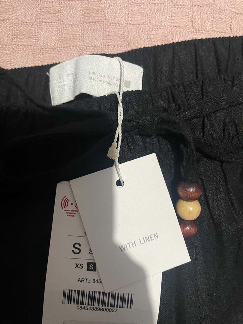 ZARA Black Linen Blend Drawstring Trousers Size S (Category: Trousers) located in Quezon City. Submitted by geohdz (Listing ID 1468310352, Image 3). Description: - Brand: ZARA - Item: Black linen blend trousers - Condition: Brand new with original tags attached - Size: S - Fit: Relaxed wide leg - Waist: Elastic waistband with wooden bead drawstring - Details: Front pockets - Origin: Made in Morocco - Fabric: Lightweight and ideal for warm weather