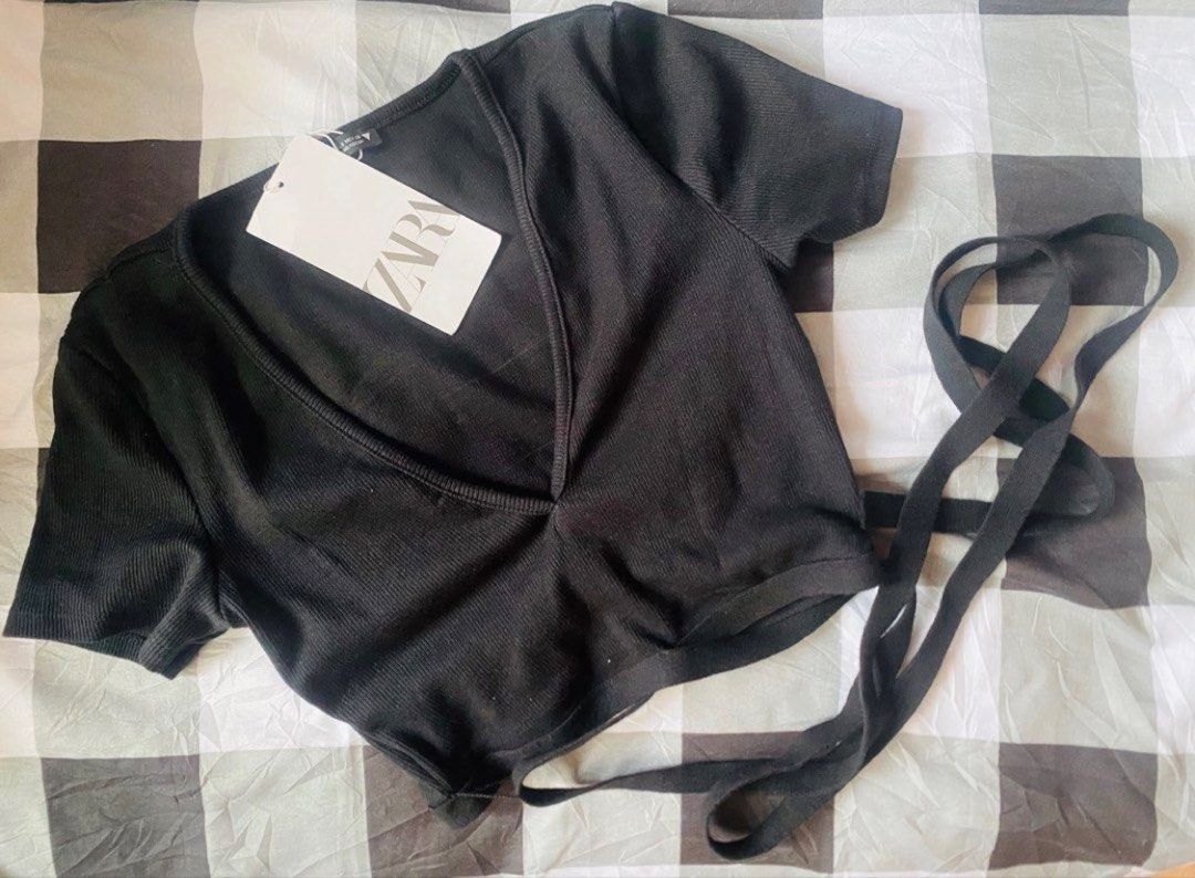 Zara Black Ribbed Wrap Crop Top Size S (Category: Sleeveless) located in Marikina City. Submitted by jessylady10 (Listing ID 1468382279, Image 1). Description: - Brand: Zara - Condition: Brand new with original tags - Size: S - Color: Black - Material: Stretchy ribbed fabric - Design: Short sleeves, deep V-neckline, and stylish wrap-around tie details at the waist - Origin: Made in Bangladesh - Style: Super versatile for everyday casual or dresse