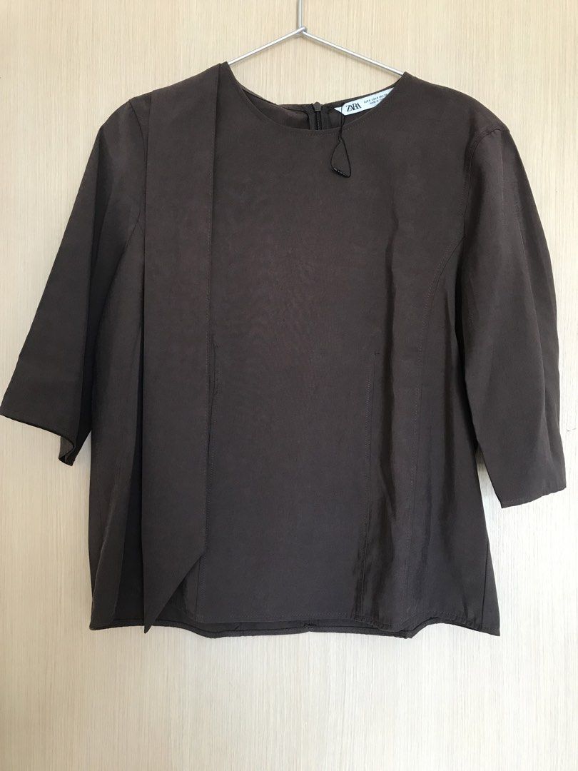 ZARA Dark Brown Blouse Size S (Category: Blouses) located in Cainta. Submitted by ukaymama (Listing ID 1468295786, Image 1). Description: - Brand: ZARA - Size: S - Color: Dark Brown - Material/Origin: Made in Turkey - Design: Short sleeves, round neckline, back zipper closure, and a unique front draped panel - Condition: Excellent, clean with no stains or damage.