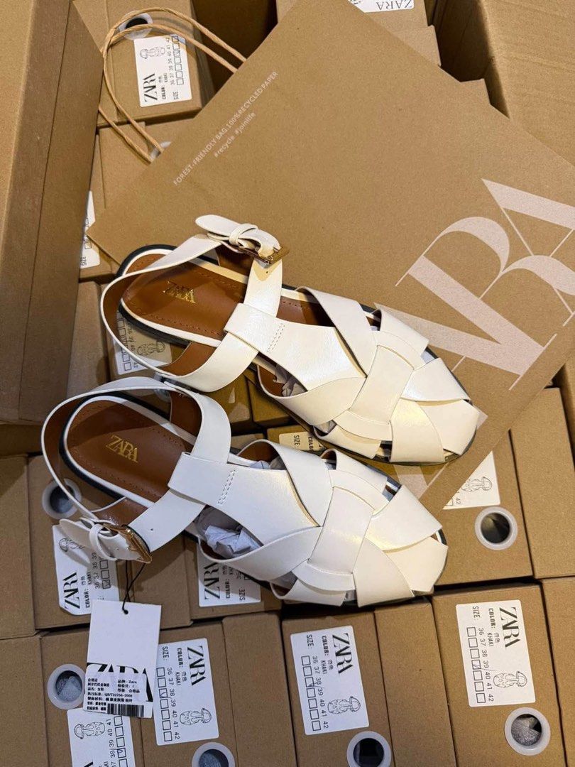 ZARA Fisherman Flat Sandals White (Category: Flats & Sandals) located in Lipa City. Submitted by thyra06 (Listing ID 1468346980, Image 2). Description: - Brand: Zara - Style: Fisherman sandals with trendy braided strap design - Color: White with brown insole and gold Zara logo - Features: Adjustable ankle buckle, flat heel, and dark outsole - Condition: Brand new with tag attached - Packaging: Original ZARA shoe box included - Sizing: Standard si
