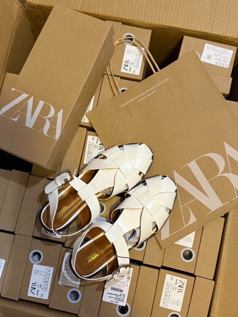 ZARA Fisherman Flat Sandals White (Category: Flats & Sandals) located in Lipa City. Submitted by thyra06 (Listing ID 1468346980, Image 3). Description: - Brand: Zara - Style: Fisherman sandals with trendy braided strap design - Color: White with brown insole and gold Zara logo - Features: Adjustable ankle buckle, flat heel, and dark outsole - Condition: Brand new with tag attached - Packaging: Original ZARA shoe box included - Sizing: Standard si