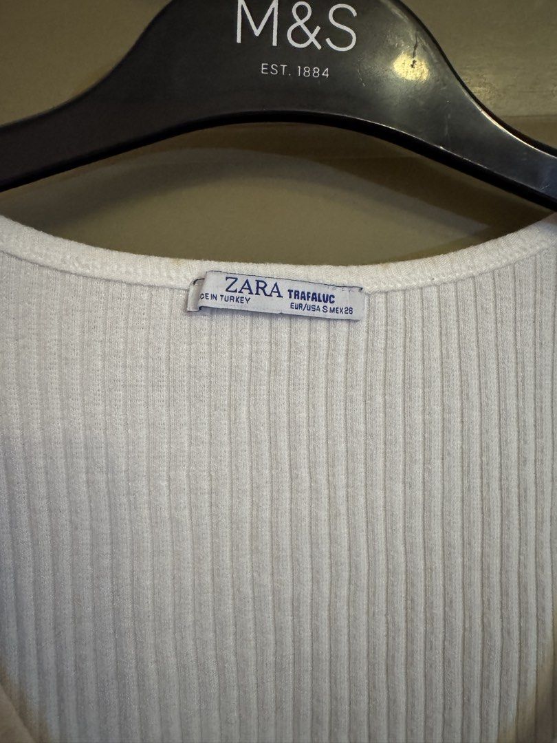 Zara Ribbed Button-Up White Top (Category: Blouses) located in Manila. Submitted by gabwie (Listing ID 1468406947, Image 3). Description: - Brand/Style: Zara Trafaluc white ribbed top - Size: S (EUR/USA S, MEX 26) - Details: Short sleeves, scoop neckline, dark tortoiseshell front buttons - Condition: Pre-loved with small yellowish stains near the button placket (please check pictures closely) - Yellowish stain can be removed with Zonrox — I can’t