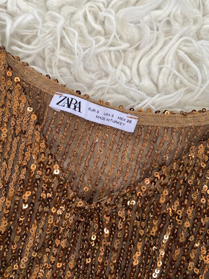Zara Sequined Top (Category: Sleeveless) located in Tabaco. Submitted by camila_dp (Listing ID 1468286600, Image 3). Description: - Brand: Zara - Size: S (EUR/USA/MEX) - Color: Rich bronze brown - Material: Semi-sheer mesh covered in sparkling sequins - Details: Thin adjustable straps, v-neckline, satin ribbon ties at the bottom hem - Origin: Made in Turkey - Condition: Great party piece / statement going out top/ Brand New / Tag Removed.