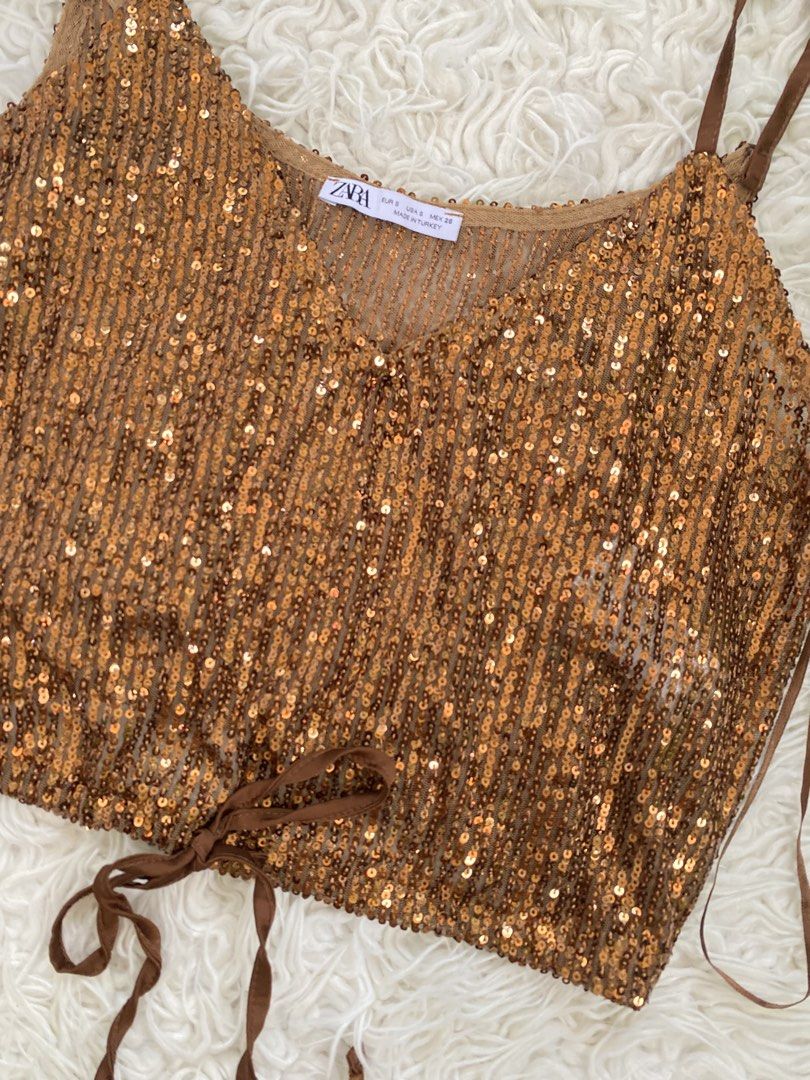 Zara Sequined Top (Category: Sleeveless) located in Tabaco. Submitted by camila_dp (Listing ID 1468286600, Image 2). Description: - Brand: Zara - Size: S (EUR/USA/MEX) - Color: Rich bronze brown - Material: Semi-sheer mesh covered in sparkling sequins - Details: Thin adjustable straps, v-neckline, satin ribbon ties at the bottom hem - Origin: Made in Turkey - Condition: Great party piece / statement going out top/ Brand New / Tag Removed.