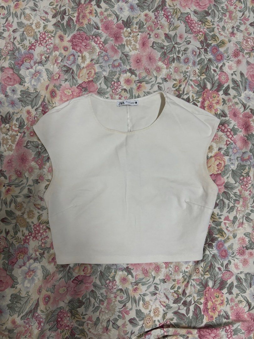 Zara White Crop Top Size S (Category: Sleeveless) located in Manila. Submitted by urthrifthany (Listing ID 1468450469, Image 1). Description: - Brand: Zara - Size: S (Made in Portugal) - Color: White - Fit: Short boxy cut - Details: Simple round neckline and cap sleeves - Material: Thick stretch fabric - Styling: Pairs great with high-waisted denim or skirts.
