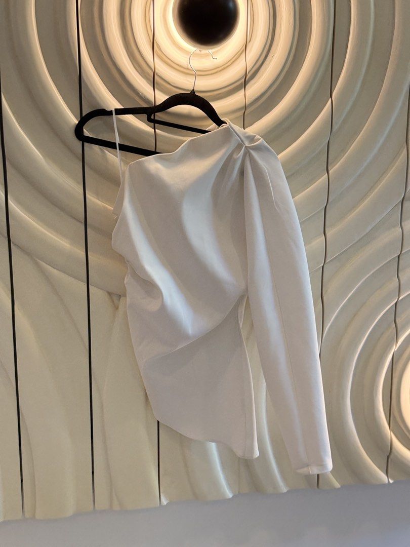 Zara White One-Shoulder Asymmetric Top Size S (Category: Sleeveless) located in Angeles City. Submitted by adeclutters__ (Listing ID 1468342142, Image 2). Description: - Brand: Zara - Size: S - Color: Clean White - Design: One-shoulder with a single long sleeve - Details: Asymmetric hemline with elegant draped fabric across the front - Origin: Made in Morocco - Condition: Excellent - Versatility: Perfect for evening outings, dates, or smart casua