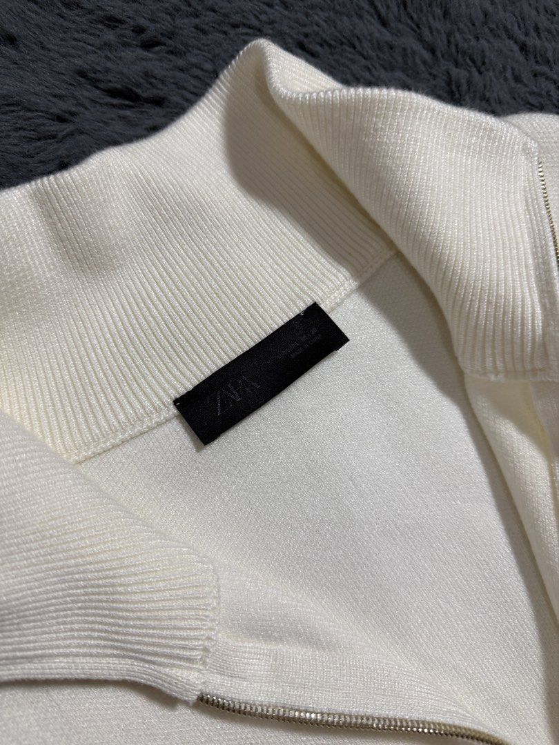 Zara White Zip-Up Knit Sweater (Category: Coats, Jackets and Outerwear) located in Las Pinas. Submitted by juls_mp (Listing ID 1468439873, Image 2). Description: - Brand: Zara - Size: L - Color: White (Neutral) - Style: Half-zip neckline with dropped shoulders for a relaxed fit - Details: Ribbed collar, cuffs, and hem - Material: Soft knit fabric - Condition: No tag but never been used.