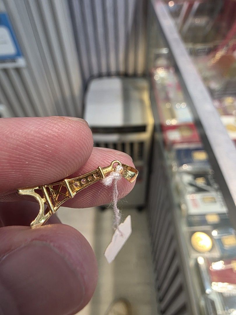 18k Eiffel Tower Gold Pendant 750 (Category: Necklaces) located in Manila. Submitted by trumpisthedevil (Listing ID 1468607659, Image 3). Description: - Material: Gold (Stamped 750 on bail) - Design: Detailed openwork Eiffel Tower with small stone accents - Weight: 1.2 grams (tag attached) - Condition: Clean and ready to wear - Note: Pendant only, chain not included.