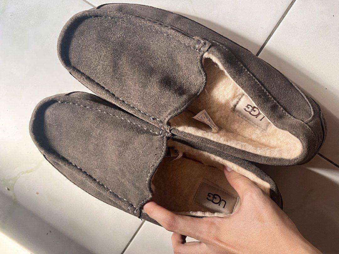 🇺🇸 UGG Brown Suede Slippers Loafers (Category: Slippers & Slides) located in Manila. Submitted by prelovedpick.com (Listing ID 1468566459, Image 2). Description: - Brand: UGG - Material: Brown suede upper with soft plush shearling lining - Style: Slip-on loafer design - Sole: Textured rubber outsole for good grip - Condition: Interior tag intact, normal wear on soles - Features: Extremely warm and comfortable for indoor/outdoor lounging.