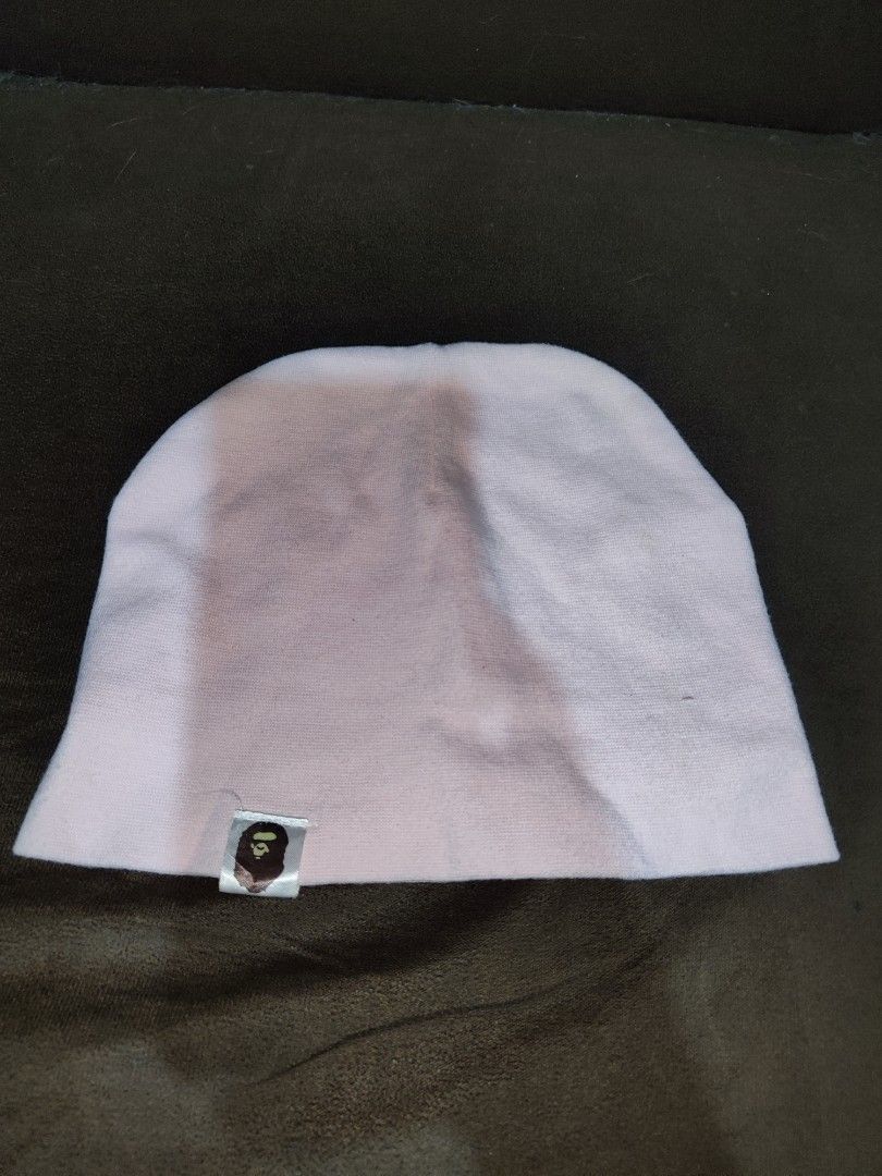 A Bathing Ape BAPE Pink Beanie with Logo Tag (Category: Caps & Hats) located in Paniqui. Submitted by arlenepari29210 (Listing ID 1468687038, Image 1). Description: - Brand: A Bathing Ape (BAPE) - Color: Light Pink - Material: Soft, comfortable cotton - Design: Classic pull-on knit beanie with signature ape head logo tag near the hem - Style: Versatile streetwear accessory, can be worn slouchy or fitted - Condition: Excellent / Great for colder d