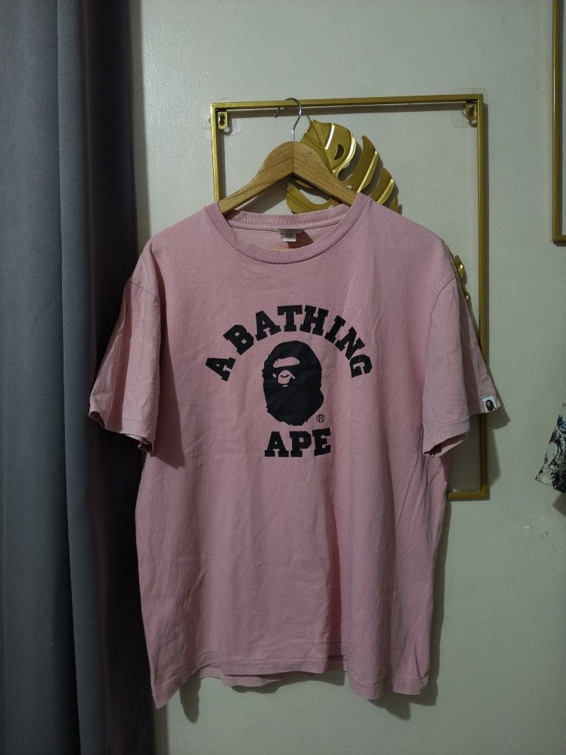 A Bathing Ape Pink T-Shirt XL (Category: Shirts) located in Manila. Submitted by bentong18188433 (Listing ID 1468617036, Image 1). Description: - Brand: A Bathing Ape (Bape) - Color: Pink - Design: Classic black ape head graphic with arched lettering on chest - Size: XL (collar tag attached) - Details: Signature small ape tag on the left sleeve - Fit: Regular fit, crewneck style - Condition: Excellent, ready to ship.