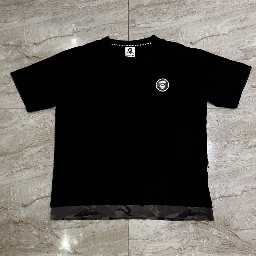 AAPE By A Bathing Ape Black Camo Tee (Category: Tshirts & Polo Shirts ) located in Polangui. Submitted by rodss7 (Listing ID 1468610742, Image 1). Description: - Brand: AAPE by A Bathing Ape - Color: Black with grey camo accent panel at the bottom hem - Size: M - Material: 100% Cotton (casual and comfortable) - Design: Classic round neckline with branded inner tape, round monkey logo patch on the left chest - Authenticity details: Size M tag at c