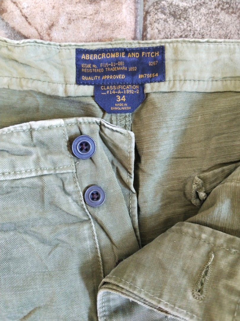 Abercrombie & Fitch utility short (Category: Shorts) located in Legazpi City. Submitted by genobecollectives (Listing ID 1468517685, Image 2). Description: - Brand: Abercrombie & Fitch - Size: 34 (inner tag) - Color: Olive green - Material: Durable cotton twill fabric - C losure: Button fly - Pockets: Multiple large cargo pockets on front and back - Details: Rugged military style with trendy raw distressed hems 500 plus sf 34 x 21.