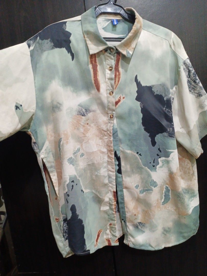 Abstract Art Print Short Sleeve Button Up Shirt (Category: Blouses) located in Manila. Submitted by ggarage.sale (Listing ID 1468689101, Image 2). Description: - Style: Short-sleeve button-up shirt with an abstract watercolor pattern - Colors: Green, beige, black, and brown tones - Fit: Relaxed boxy fit with a pointed collar - Material: Lightweight fabric for comfortable wear - Versatility: Ideal for casual everyday wear or weekend outings.