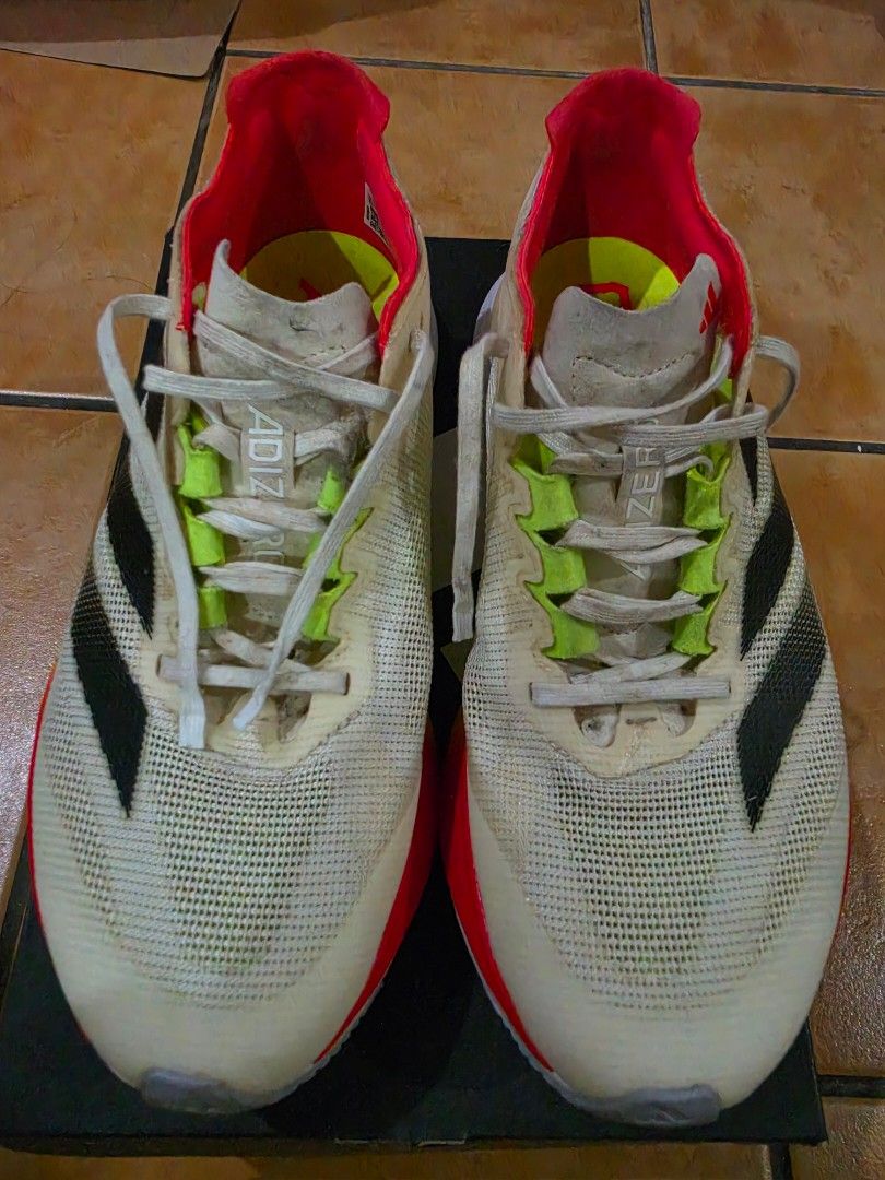 Adidas Adizero Boston 12 W (Category: Sneakers) located in Paranaque City. Submitted by krisfuentes (Listing ID 1468674417, Image 1). Description: - Brand/Model: Adidas Adizero Boston 12 W - Size: US 7.5 / UK 6 / EUR 39 1/3 / JP 245 / CHN 240 - Colorway: White upper with black stripes, red lining, and neon accents - Sole/Cushioning: Lightstrike Pro midsole foam with Continental rubber outsole - Condition: Pre-loved with visible dirt on the outsol