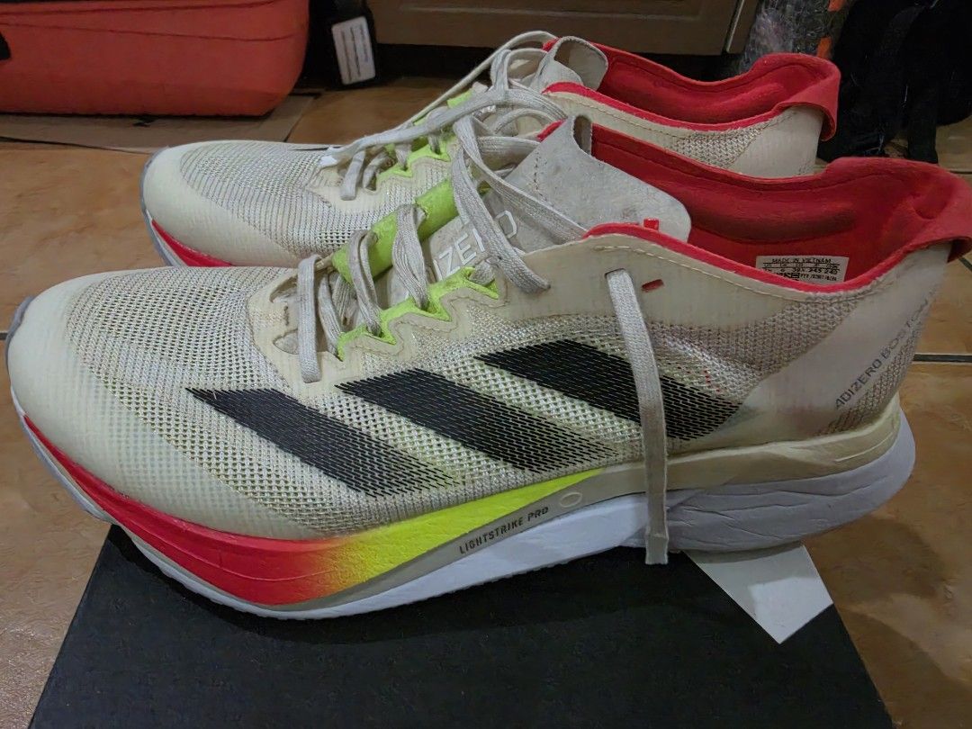 Adidas Adizero Boston 12 W (Category: Sneakers) located in Paranaque City. Submitted by krisfuentes (Listing ID 1468674417, Image 2). Description: - Brand/Model: Adidas Adizero Boston 12 W - Size: US 7.5 / UK 6 / EUR 39 1/3 / JP 245 / CHN 240 - Colorway: White upper with black stripes, red lining, and neon accents - Sole/Cushioning: Lightstrike Pro midsole foam with Continental rubber outsole - Condition: Pre-loved with visible dirt on the outsol