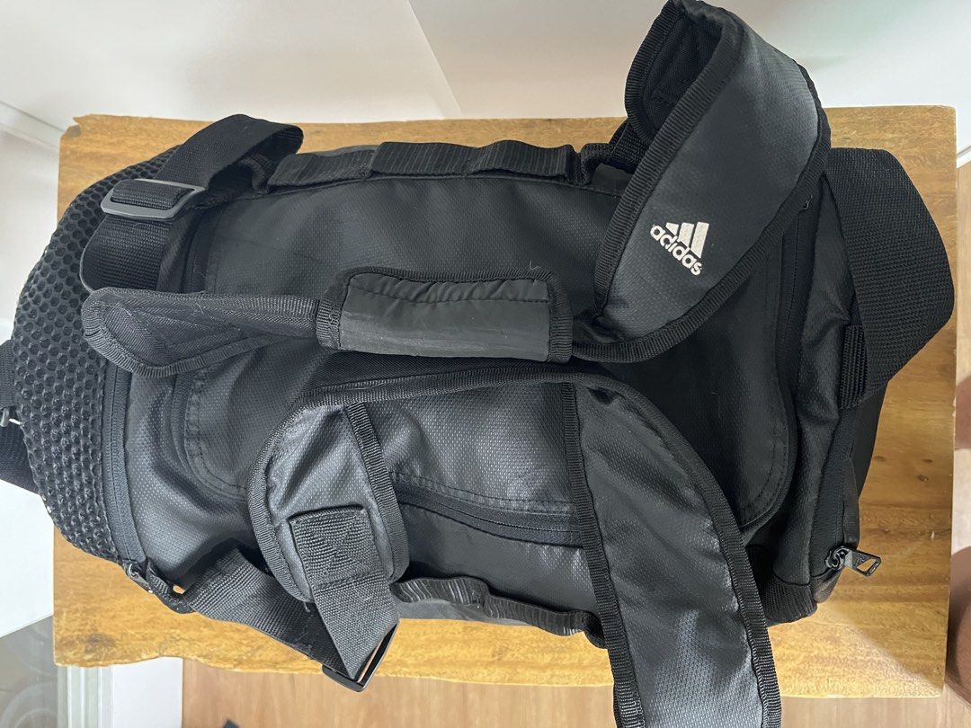 Adidas Black Duffel Gym Bag (Category: Sling Bags) located in Mandaluyong City. Submitted by unomarcelo001 (Listing ID 1468540667, Image 2). Description: - Authentic Black Adidas duffel bag - Durable, textured solid build with a clean interior and exterior - Dual carry handles and an adjustable padded shoulder strap with branding - Convenient side mesh pocket for quick access items - Spacious main zip compartment with a striking bright blue inner