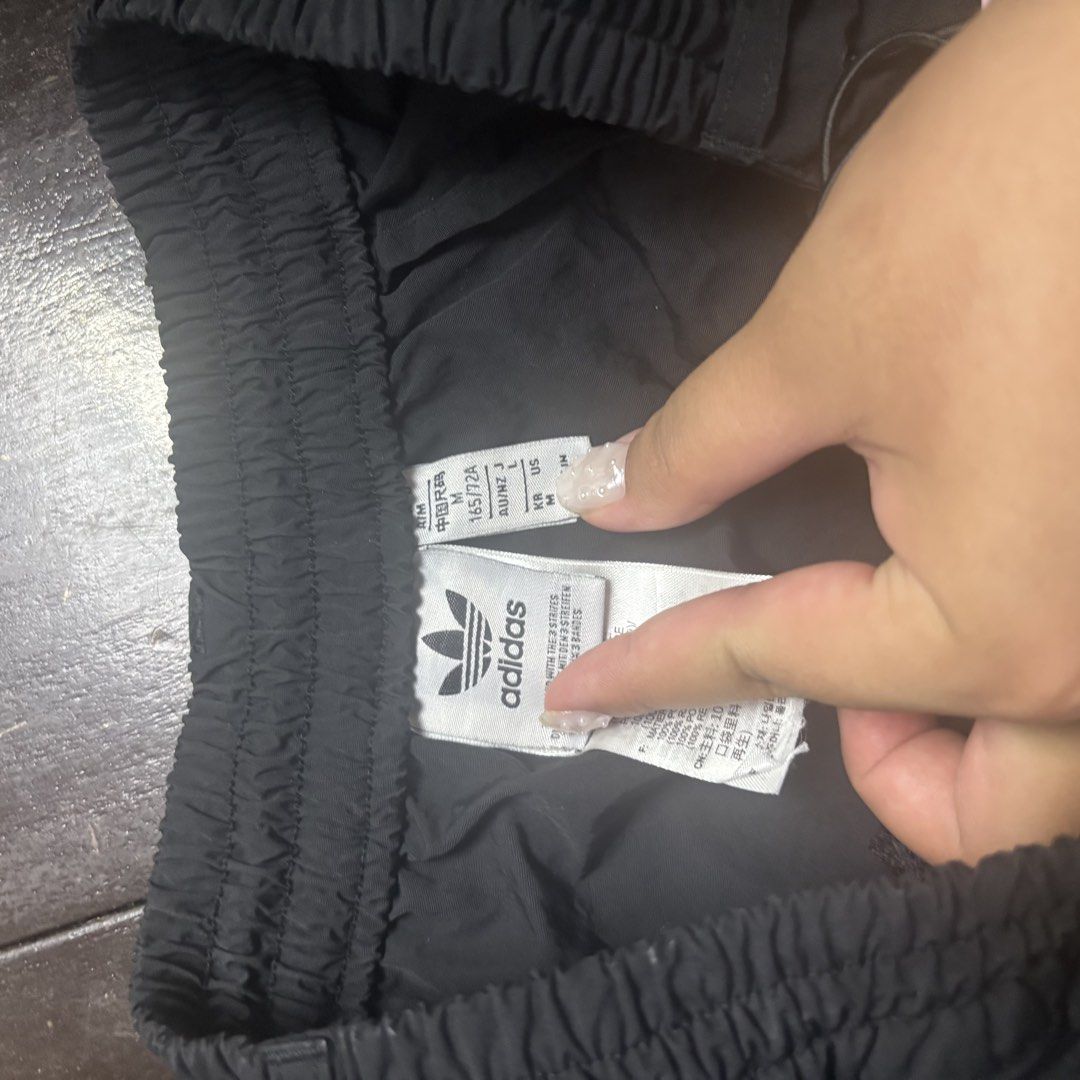 Adidas Black Track Pants Size M (Category: Joggers) located in Manila. Submitted by waywaya (Listing ID 1468596244, Image 2). Description: - Brand: Adidas - Color: Classic black with white trefoil logo and three stripes - Size: Tag M (Waist: 14 in across, Length: 39.5 in) - Features: Elastic waistband with adjustable drawcords, convenient zippered side pockets - Material: Lightweight and breathable for easy movement Meetups are possible in Ubelt 