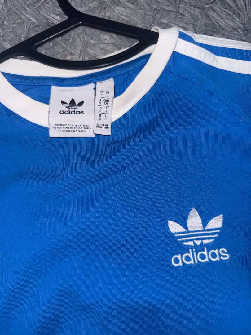 Adidas Blue Three Stripe Jersey (Category: Tshirts & Polo Shirts ) located in Quezon City. Submitted by ashhaul (Listing ID 1468562789, Image 3). Description: - Brand: Adidas - Color: Blue with white ringer collar and stripes - Logo: Classic embroidered trefoil on chest - Size: S (Fits true to size) - Material: Comfortable cotton blend - Condition/Use: Great casual piece for everyday wear.