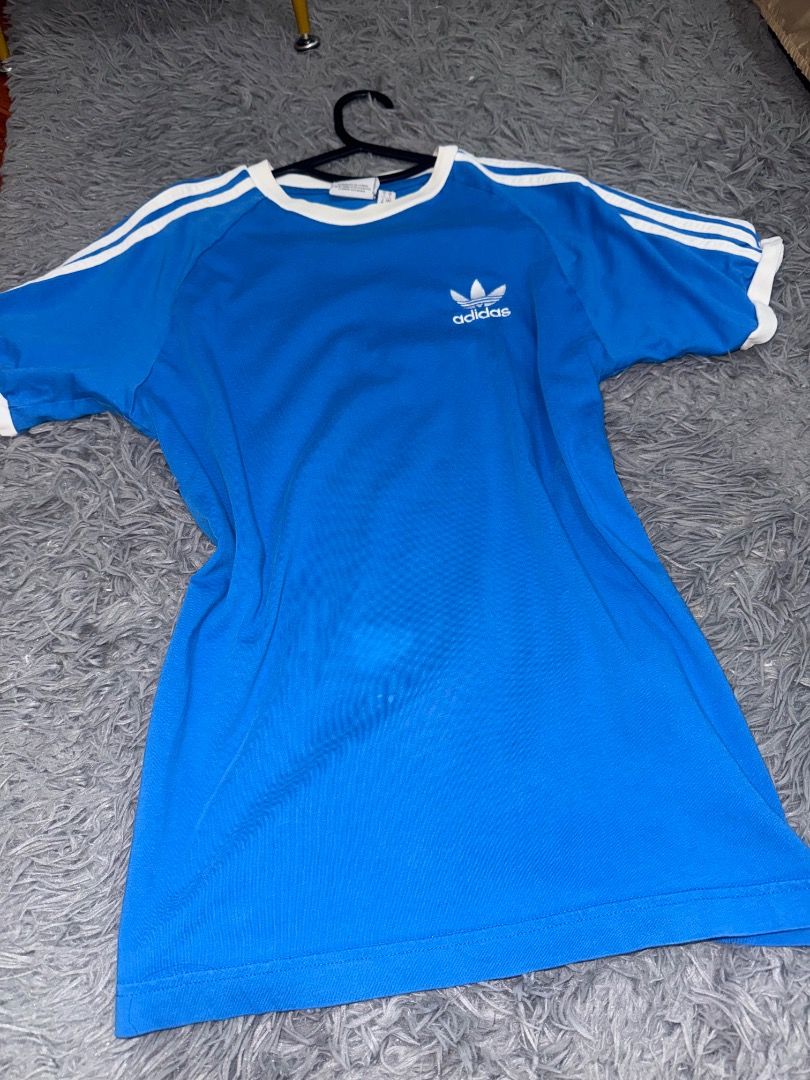 Adidas Blue Three Stripe Jersey (Category: Tshirts & Polo Shirts ) located in Quezon City. Submitted by ashhaul (Listing ID 1468562789, Image 2). Description: - Brand: Adidas - Color: Blue with white ringer collar and stripes - Logo: Classic embroidered trefoil on chest - Size: S (Fits true to size) - Material: Comfortable cotton blend - Condition/Use: Great casual piece for everyday wear.