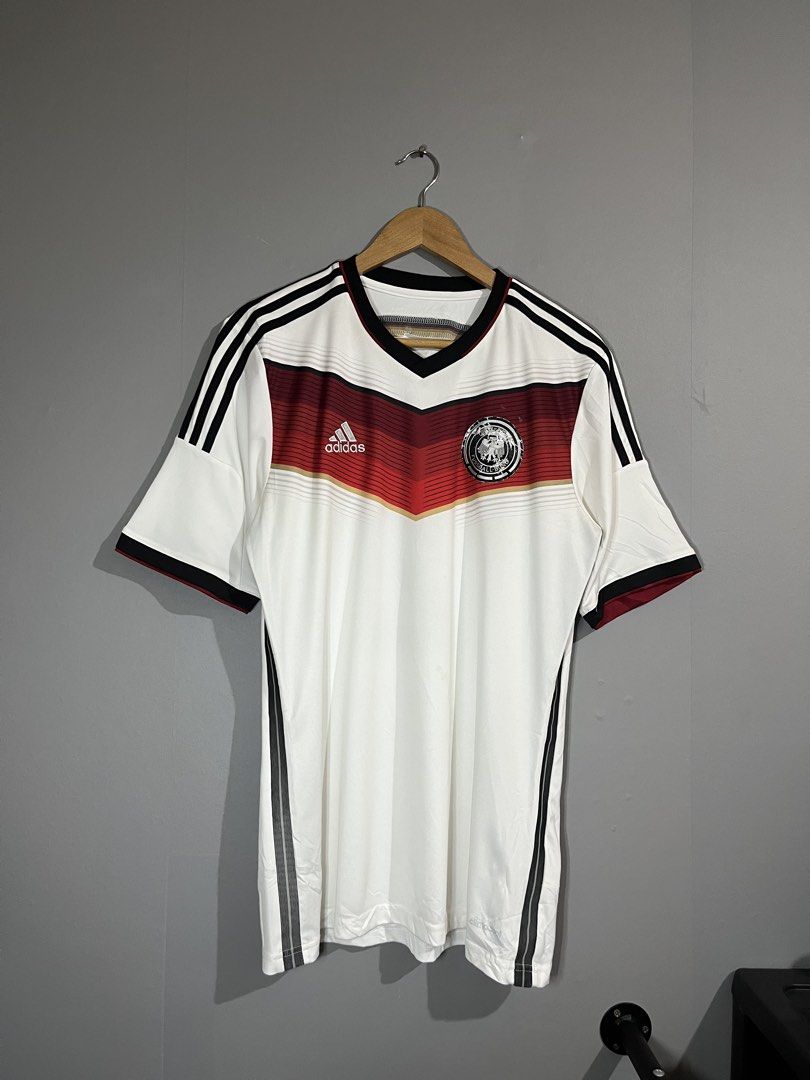 Adidas Germany Home World Cup Jersey (Category: Activewear) located in Butuan. Submitted by thriftheadsofficial (Listing ID 1468505808, Image 1). Description: - Official Adidas Germany home football jersey - Iconic black, red, and gold chest chevron graphic - Classic v-neck collar with black trim and shoulder stripes - Official licensed product tag intact - Standard fit short sleeve kit - Made in China.