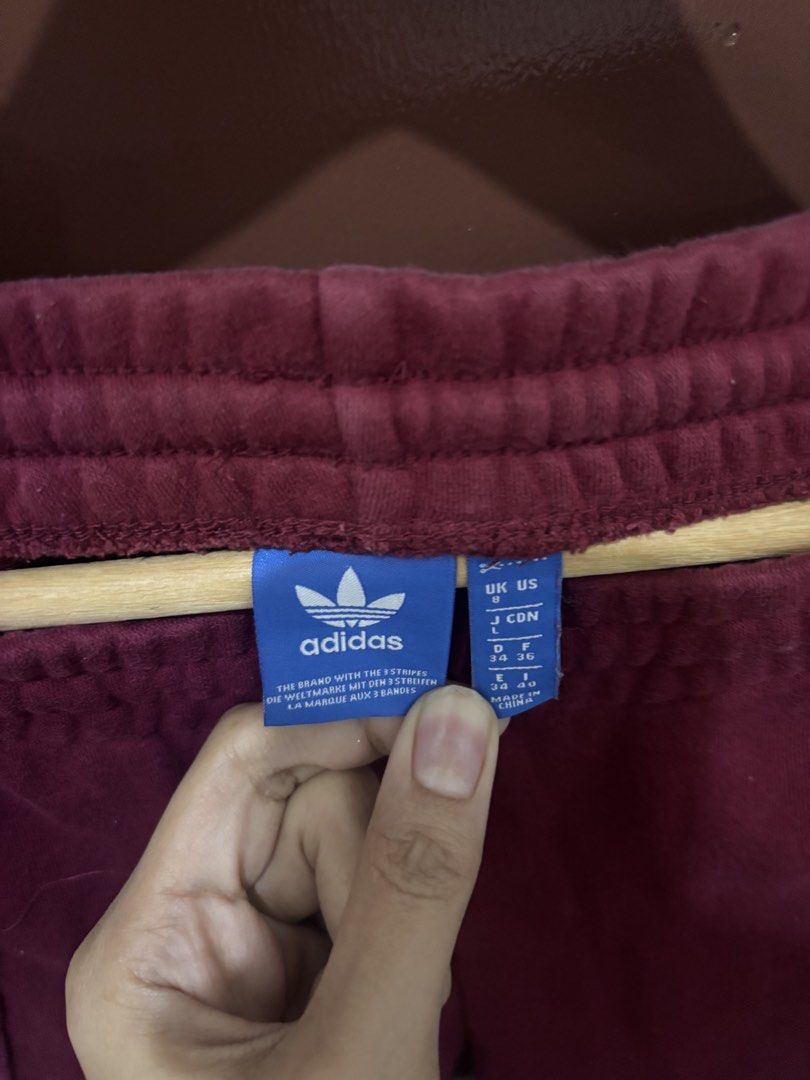 Adidas Maroon Track Pants Size (Category: Joggers) located in Quezon City. Submitted by juiriya (Listing ID 1468653093, Image 3). Description: - Color: Rich Maroon - Material: Soft and cozy velour fabric - Size: UK 8, US S, D 34, F 36, E 34, I 40 (fits Small) - Waistband: Elastic with adjustable drawstring - Pockets: Convenient zippered pockets on both sides - Details: Embroidered Adidas trefoil logo on the left leg & ribbed ankle cuffs .