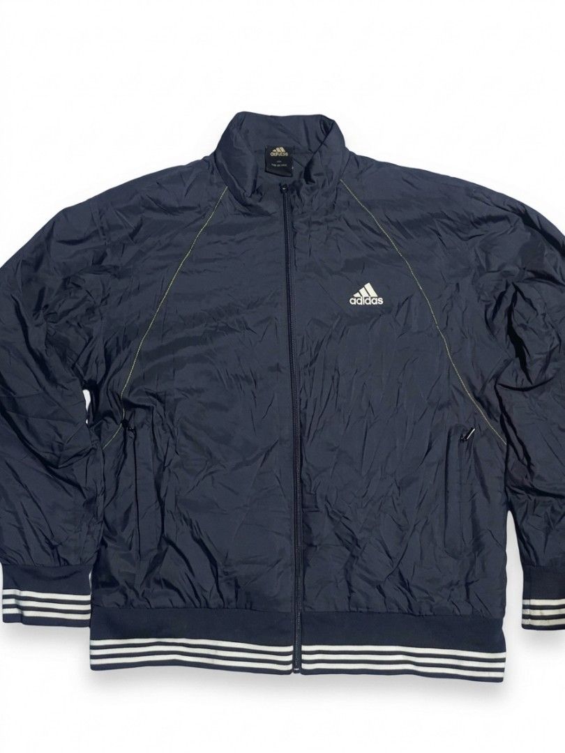 Adidas Navy Thin Padded Track Jacket Size 105 (Category: Coats, Jackets and Outerwear) located in City of Isabela. Submitted by warmbird.d06e6f (Listing ID 1468617072, Image 1). Description: - Brand: Adidas - Color: Navy blue with white logo - Size: 105 (Made in Korea) - Style: Full zip, thin padded, ribbed striped cuffs and hem - Features: Two front zippered pockets - Condition: Comfortable layering piece, perfect for cooler weather.