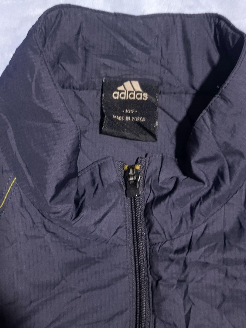 Adidas Navy Thin Padded Track Jacket Size 105 (Category: Coats, Jackets and Outerwear) located in City of Isabela. Submitted by warmbird.d06e6f (Listing ID 1468617072, Image 2). Description: - Brand: Adidas - Color: Navy blue with white logo - Size: 105 (Made in Korea) - Style: Full zip, thin padded, ribbed striped cuffs and hem - Features: Two front zippered pockets - Condition: Comfortable layering piece, perfect for cooler weather.