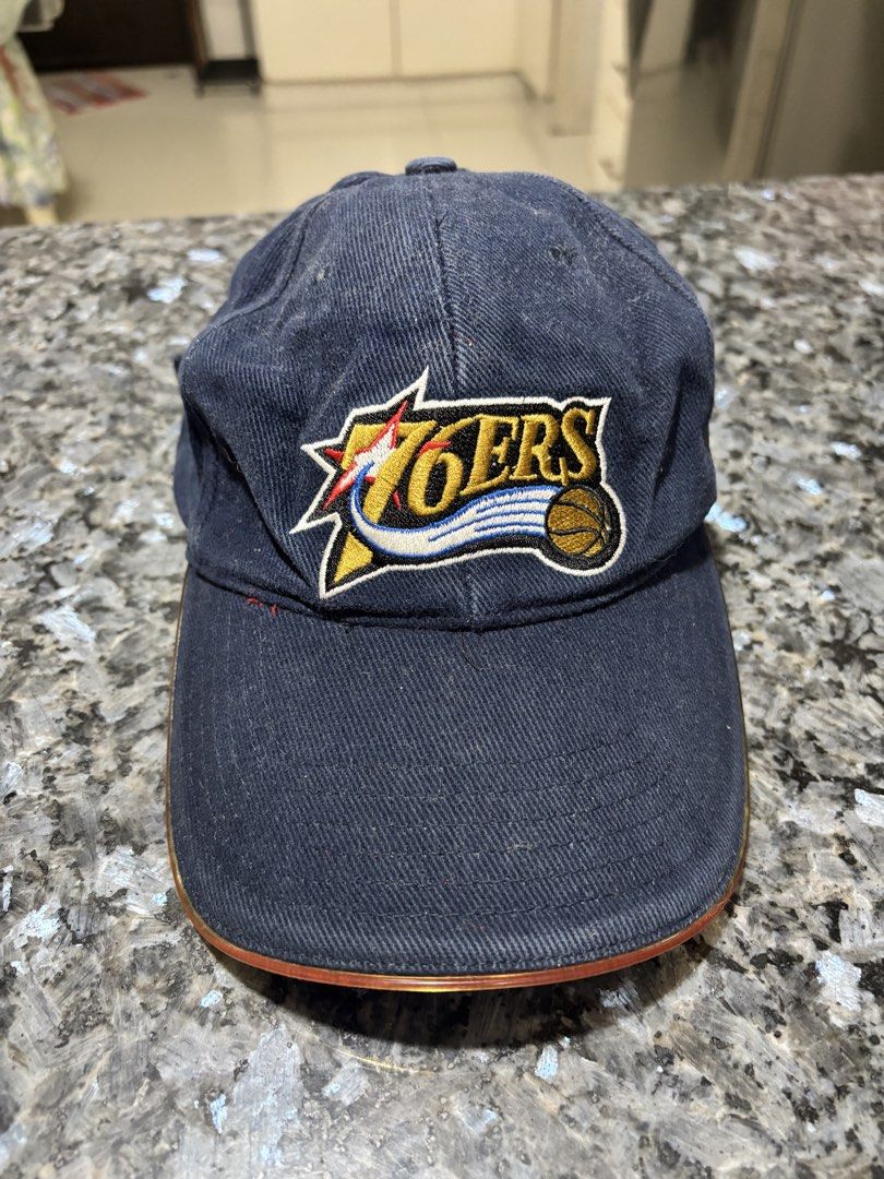 Adidas Philadelphia 76ers NBA Strapback Cap (Category: Caps & Hats) located in Taytay. Submitted by chippylala (Listing ID 1468641407, Image 1). Description: - Authentic Adidas Philadelphia 76ers hat in classic navy blue - Features embroidered team logo on the front and NBA patch on the side - Adjustable metal slider strap at the back for a custom fit - Made from durable and comfortable cotton twill fabric - Condition: Shows light wear and dust, 