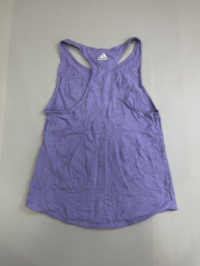 Adidas Purple Racerback Tank Top (Category: Activewear) located in Mabalacat. Submitted by aas_thriftfings (Listing ID 1468576996, Image 2). Description: - Brand: Adidas - Color: Purple - Style: Racerback tank top, casual athletic wear - Size: XS (with international equivalents on tag) - Design: Large white logo on the chest and smaller graphic on the upper back - Origin: Made in Cambodia - Condition: Excellent for workouts or daily wear.