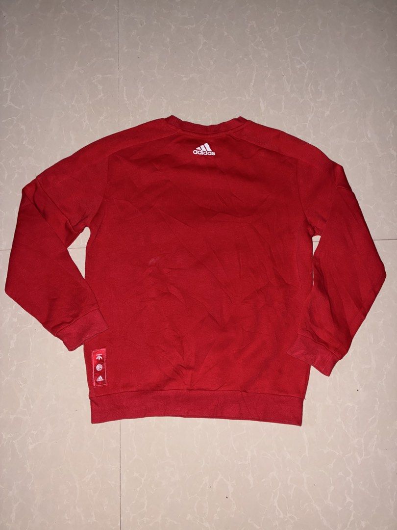 Adidas Red Dragon Graphic Sweatshirt (Category: Coats, Jackets and Outerwear) located in Placer. Submitted by talaalond61563 (Listing ID 1468711785, Image 2). Description: - Color: Bright red - Material: Comfortable, solid cotton for everyday wear - Front Design: Bold Chinese dragon art inside a square box with a white Adidas logo in the middle - Back Design: Small white Adidas logo near the collar - Hem Detail: Matching red patch near the bottom