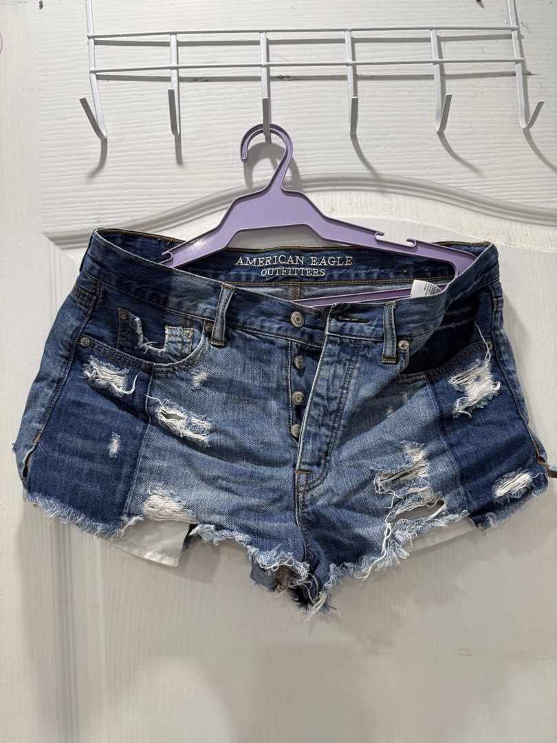 American Eagle Outfitters Distressed Denim Shorts (Category: Shorts) located in Manila. Submitted by prelov3dbysteph (Listing ID 1468550794, Image 1). Description: - Brand: American Eagle - Style: High-waisted denim shorts with button fly - Wash: Medium blue with heavy distressing - Details: Frayed raw hems and contrasting darker denim back patch pocket - Pockets: Classic five-pocket styling - Condition: Excellent, ready to wear.