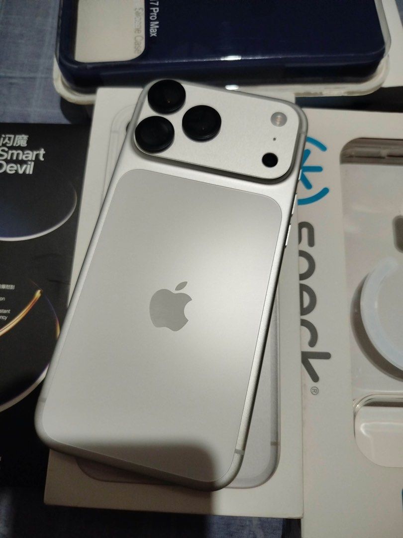 Apple iPhone Pro Max Silver with Phone Cases and Accessories (Category: iPhone 17 Series) located in Makati City. Submitted by caloy1017 (Listing ID 1468692656, Image 2). Description: - Model: Silver iPhone Pro Max in pristine, scratch-free condition (front and back) - Condition: Clean body with fully functional buttons, USB-C port, and triple camera setup - Inclusions: Beyond the Box paper bag, dark blue phone case, Speck MagSafe case packaging,