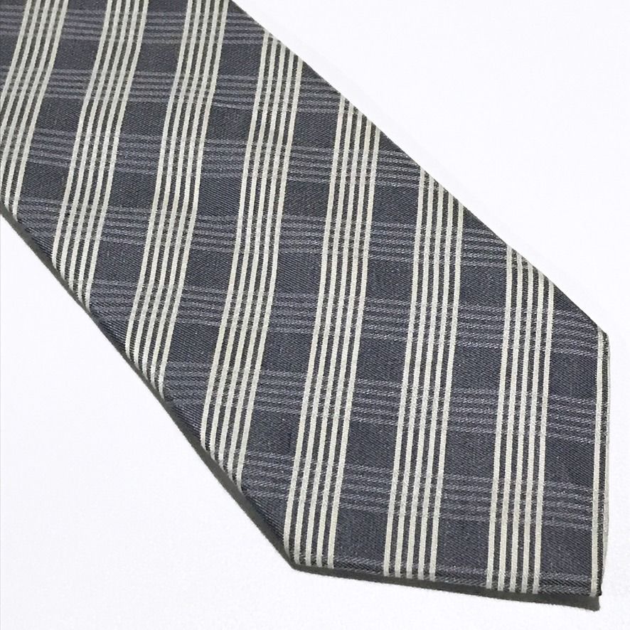 ARALON Plaid Gray Neck Tie (Category: Ties) located in Taguig. Submitted by retrogaze (Listing ID 1468561764, Image 2). Description: This textured necktie by ARALON features a charcoal-grey base woven in a multi-textured twill ground. The blade showcases a geometric bias plaid pattern composed of subtle shadow-checked blocks interwoven with sharp, light cream pinstripe bands. Brand Overview ARALON is a practical Japanese menswear accessories labe