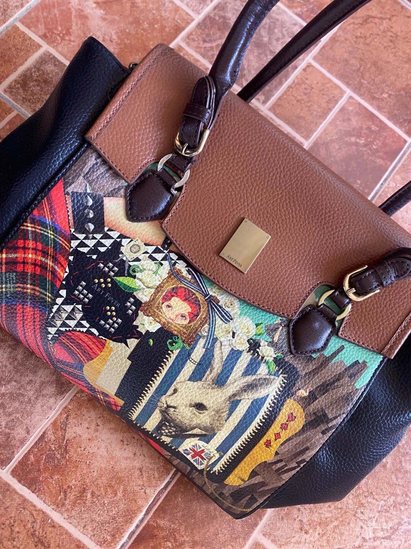 Art Fever patchwork handbag with rabbit graphic design (Category: Tote Bags) located in Dagupan City. Submitted by shanadongsb (Listing ID 1468665271, Image 2). Description: - Brand: Art Fever - Design: Unique patchwork style with vibrant graphic prints, rabbit details, and artwork accents - Colorway: Mix of brown, black, and colorful prints with gold-tone hardware - Handles: Comfortable double brown top handles - Interior: Vibrant purple fabric 