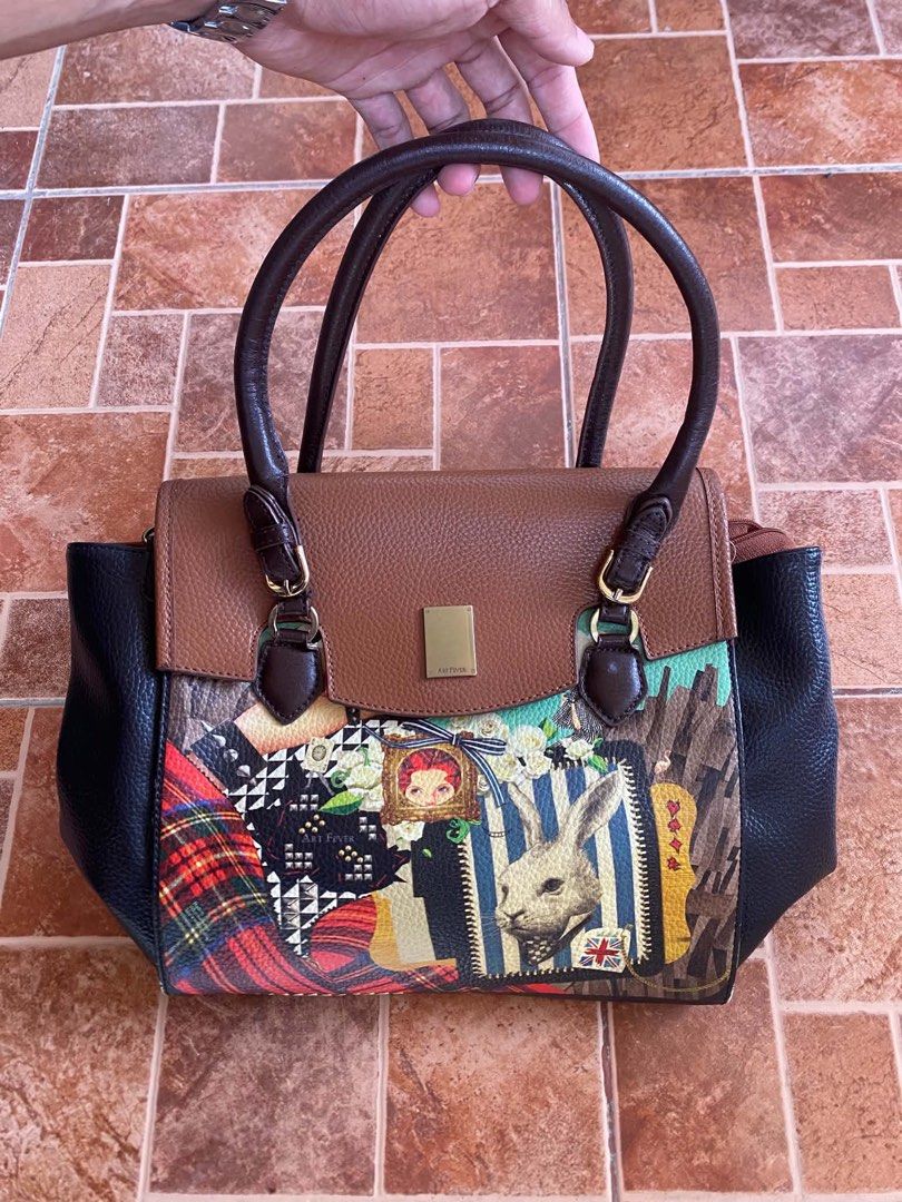 Art Fever patchwork handbag with rabbit graphic design (Category: Tote Bags) located in Dagupan City. Submitted by shanadongsb (Listing ID 1468665271, Image 1). Description: - Brand: Art Fever - Design: Unique patchwork style with vibrant graphic prints, rabbit details, and artwork accents - Colorway: Mix of brown, black, and colorful prints with gold-tone hardware - Handles: Comfortable double brown top handles - Interior: Vibrant purple fabric 