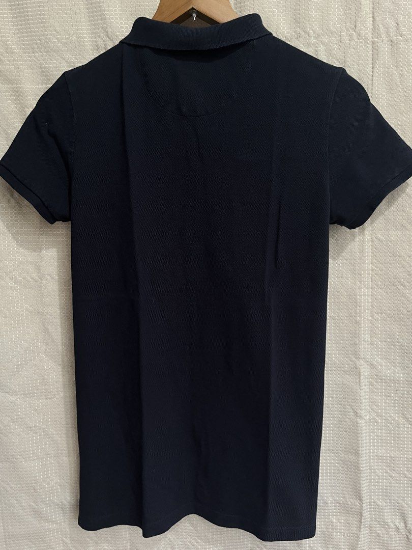 Authentic Burberry Polo Shirt (Category: Shirts) located in Davao. Submitted by aelane.listings (Listing ID 1468499976, Image 2). Description: Color: Black or dark blue Size: 14 Youth on tag, may fit XS-S adult Measurements: 16 1/2in x 25in - Iconic nova check pattern on inside collar and placket - Small embroidered equestrian knight on left chest - Two pearl-tone front buttons Short sleeves, ribbed cuffs and collar Condition: Well-used Clean dar