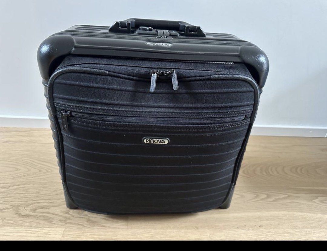 Authentic Rimowa Black Business Trolley (Category: Luggage) located in Taguig. Submitted by mhl.online.yardsale (Listing ID 1468556207, Image 1). Description: - Authentic black Rimowa rolling pilot case - Sturdy polycarbonate frame with durable fabric front pockets - Dual zip compartments up front with branded metal plaque - Multi compartments with laptop sleeves - Telescopic top handle for easy maneuvering - Integrated combination lock on the to