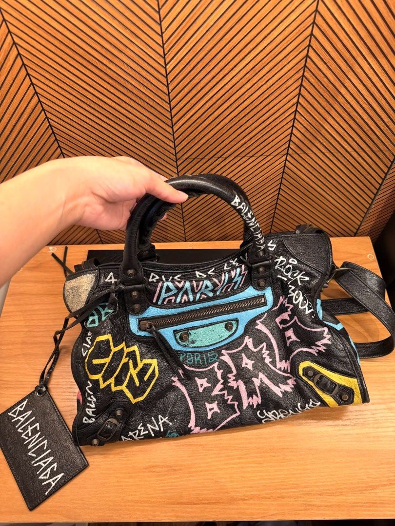 Balenciaga graffiti city bag (Category: Luxury Bags & Wallets) located in Carmona. Submitted by beajuan (Listing ID 1468562104, Image 1). Description: Guaranteed Authentic Balenciaga city bag in graffiti black arena Convertible to Crossbody and shoulder No major flaw Rated 9/10 condition from IG shop (consignment) Actual photos are posted Can do meet up at Carmona/Binan.