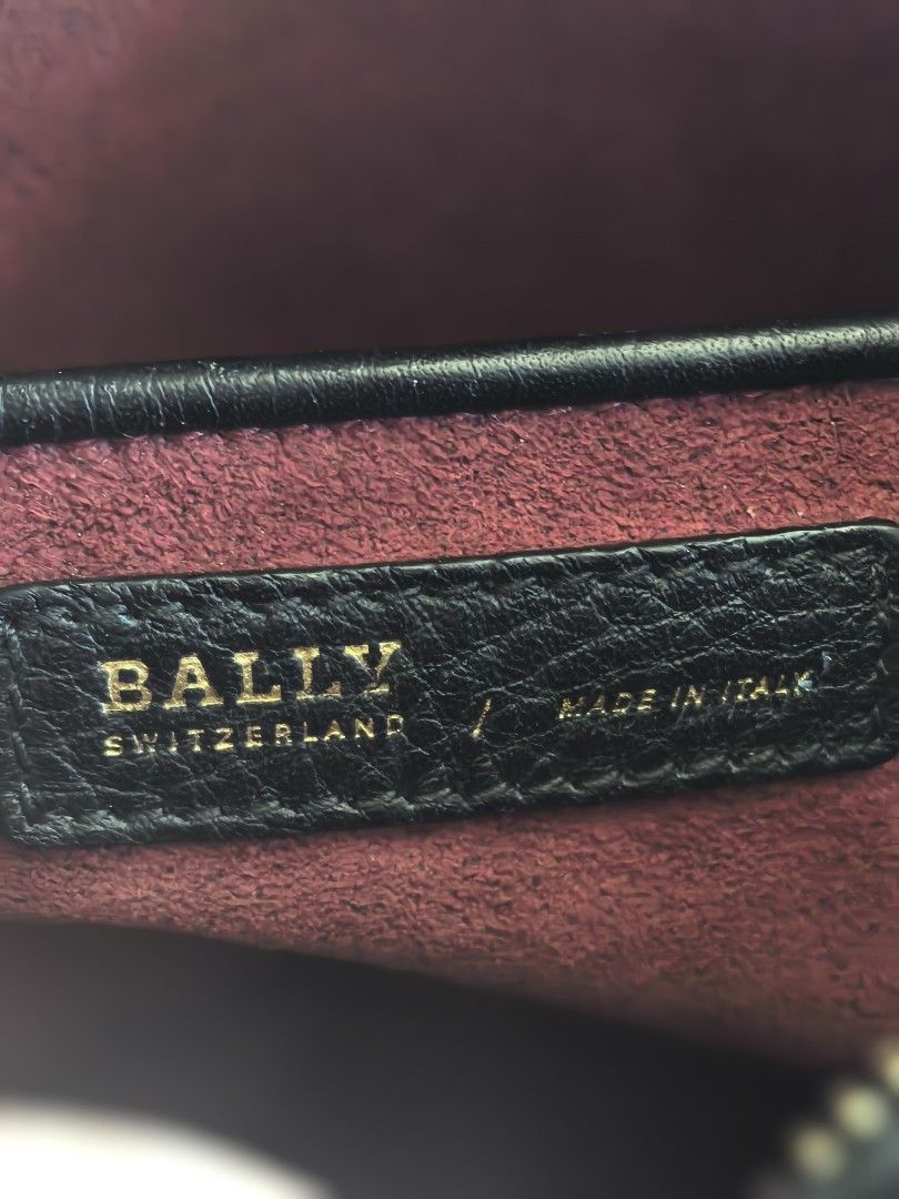 Bally Leather Crossbody Bag (Category: Luxury Bags & Wallets) located in Cagayan de Oro. Submitted by tommygurl1218 (Listing ID 1468506289, Image 3). Description: - Brand: Bally Switzerland (Made in Italy) - Material: Premium black pebbled leather with textured dark red interior lining - Design: Large embossed 'B' letter on the front flap - Hardware: Gold-tone with engraved Bally branding - Strap: Adjustable leather shoulder strap - Condition: Ex