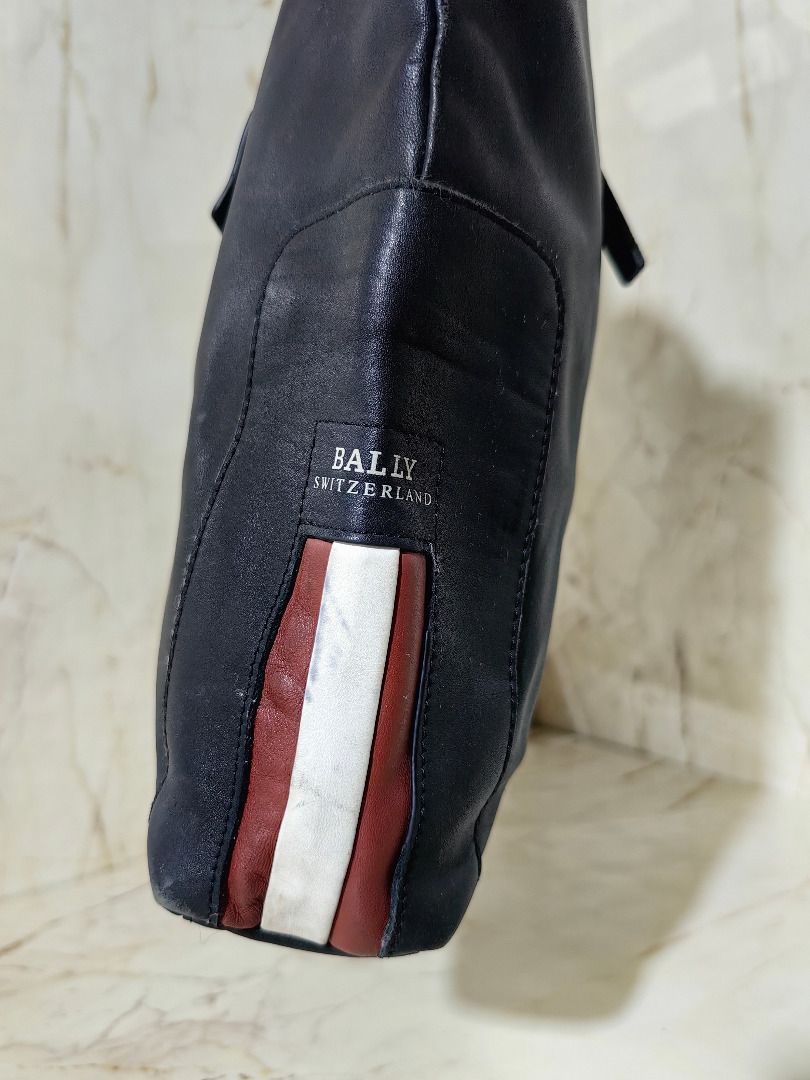 Bally Switzerland Black Tote Bag (Category: Tote Bags) located in Tarlac. Submitted by jeremiah.curator.2026 (Listing ID 1468665563, Image 2). Description: - Authentic black leather Bally Switzerland tote bag - Signature red and white stripe accent on the side panel - Dual top handles for comfortable carrying - Secure silver-tone hardware zip closure - Roomy interior perfect for holding daily essentials - Condition: Shows gentle signs of wear on 