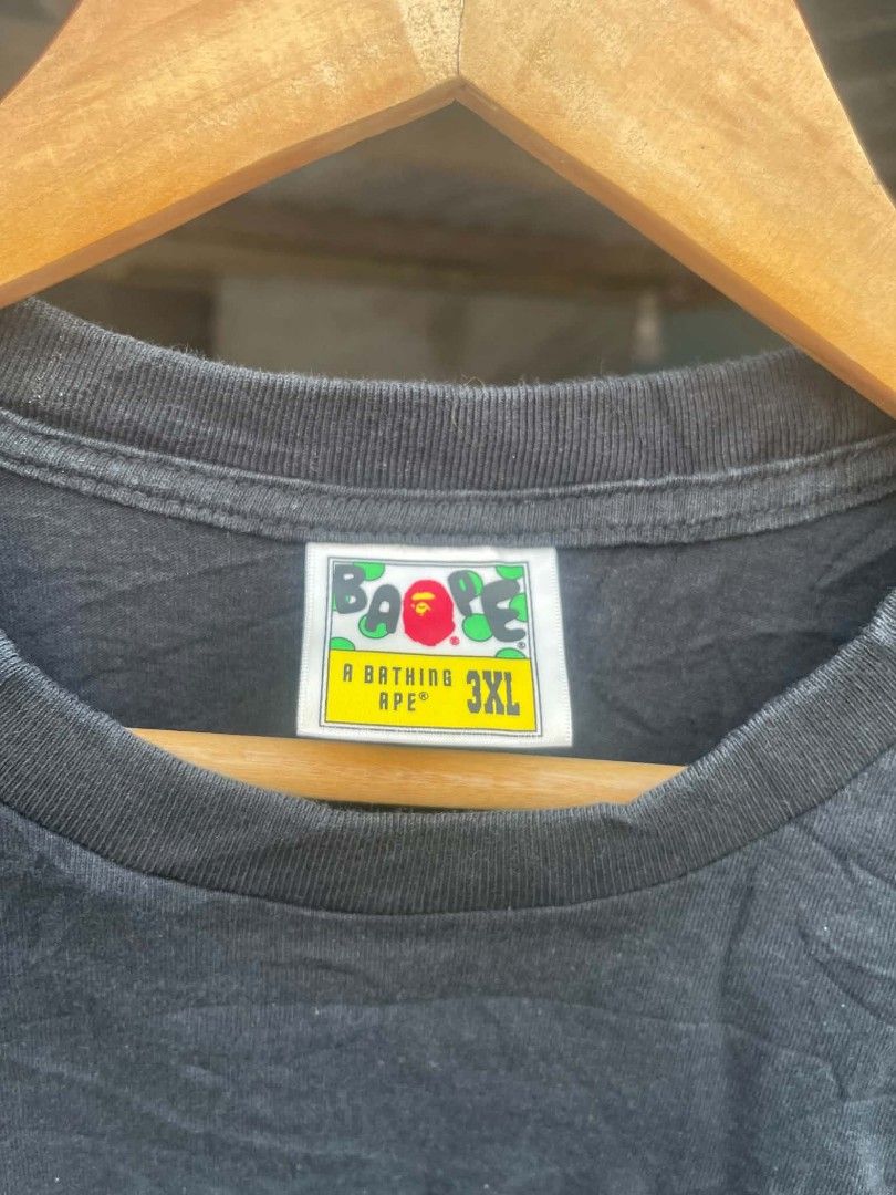 BAPE Shark Tee Black 3XL (Category: Tshirts & Polo Shirts ) located in Manila. Submitted by gregorioju41138 (Listing ID 1468595820, Image 2). Description: - Brand: BAPE - Color: Black - Size: 3XL (neck tag with green camo framing) - Design: Signature center shark face graphic with zipper detail - Detail: Classic sleeve ape head logo patch near the cuff - Condition: Minor fading from regular washing and wear - 100% authentic, perfect for streetwea