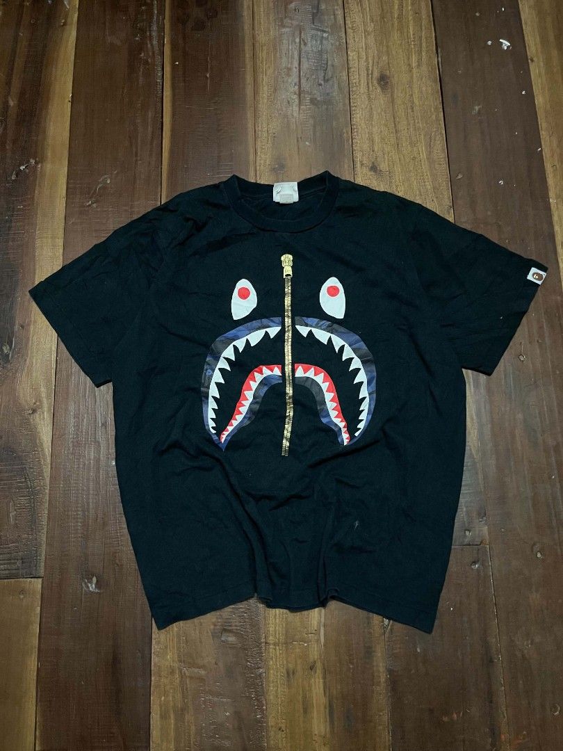 BAPE Shark Zip Graphic Tee Black Size M (Category: Tshirts & Polo Shirts ) located in Manila. Submitted by adzwilnams67005 (Listing ID 1468656423, Image 1). Description: BAPE graphic t-shirt in black. Iconic shark face print on the front with a gold zipper graphic down the center. Classic A Bathing Ape neck tag and wash label attached. Size medium, standard fit. 100% cotton material. Good streetwear staple. Bape shark ‎ ‎Size M on tag ‎Dimes:21.5