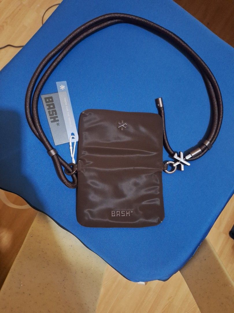 BASH mini cache wallet in terra (Category: Cross-body Bags) located in Caloocan City. Submitted by _mie3 (Listing ID 1468686797, Image 3). Description: - Brand: BASH - Condition: Brand new with original tag - Color: Terra - Material: Shiny nylon-like fabric - Strap: Long rope strap with logo accents - Closure: Magnetic or fold-over design - Perfect for keeping cards, cash, and small essentials secure while on the go.