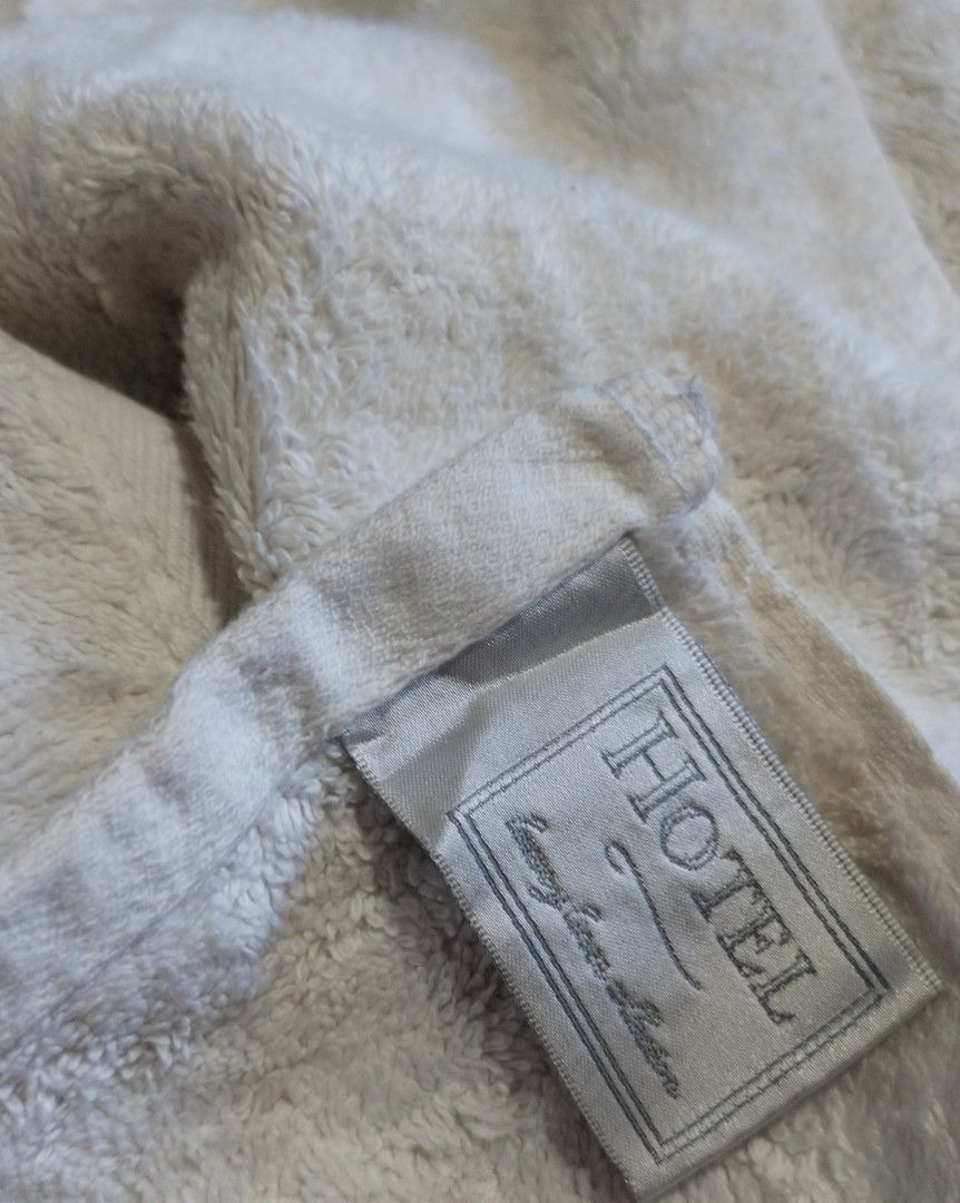 Bath Towel Cotton (Category: Bathroom & Kitchen Fixtures) located in Muntinlupa City. Submitted by arciagamaryann68 (Listing ID 1468594974, Image 3). Description: - Premium hotel-grade bath towel featuring a clean white color - Thick, plush, and highly absorbent terry cloth material for maximum comfort - Elegant textured border design near the edge - Includes original 'HOTEL' brand label - Well-maintained, clean, and in great overall condition - 