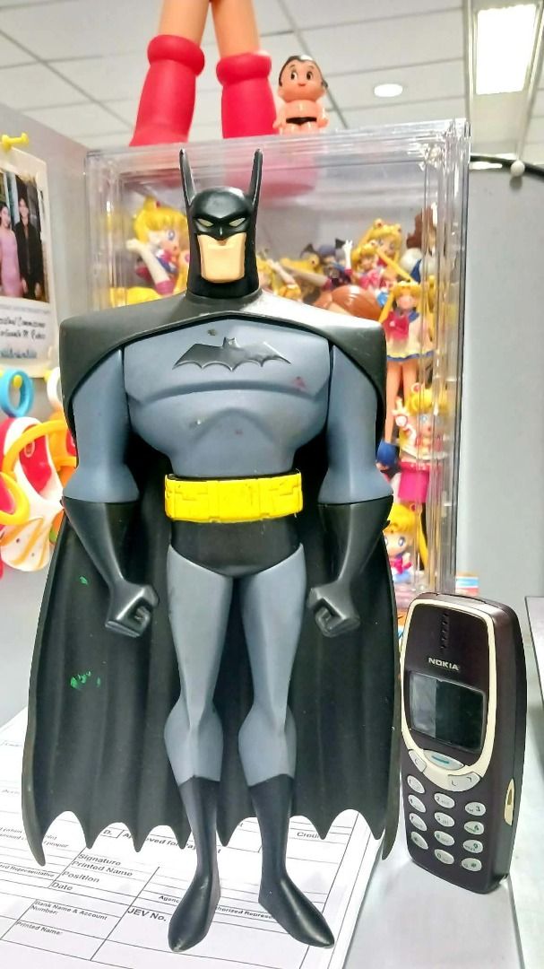 BATMAN 11inches Animated Series (Category: Vintage Collectibles) located in Manila. Submitted by mickey_salonga (Listing ID 1468606813, Image 2). Description: - DC Animated Series Batman action figure - Classic gray and black suit with yellow utility belt - Stands upright on its own - Cape attached at the shoulders - Perfect nostalgic piece for collectors - Note: Nokia phone in photo is for scale only.