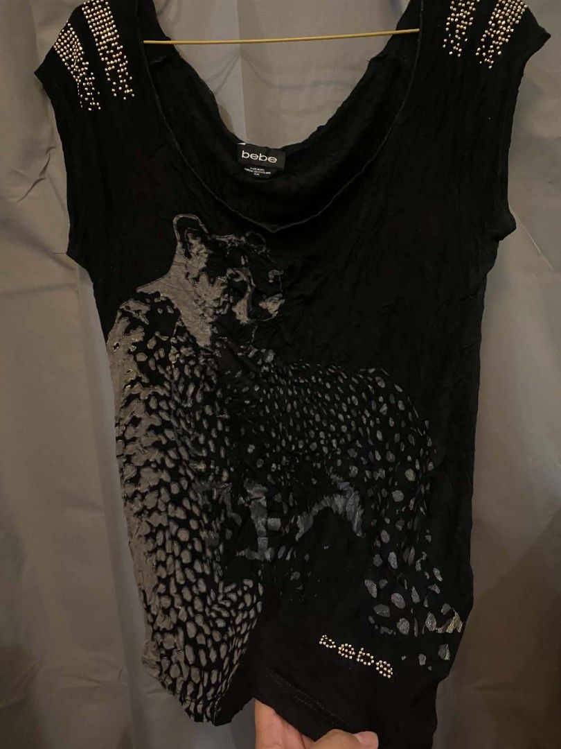 bebe Black Leopard Print Studded Shoulder Top (Category: Sleeveless) located in Malasiqui. Submitted by finnley26 (Listing ID 1468535967, Image 1). Description: - Brand: bebe - Size: Large - Color: Black with grey leopard graphic - Details: Gold studs on shoulders & small rhinestone logo near hem - Neckline: Wide scoop neck - Fabric: Soft, comfortable with crinkled texture throughout - Condition: Excellent, well-maintained.