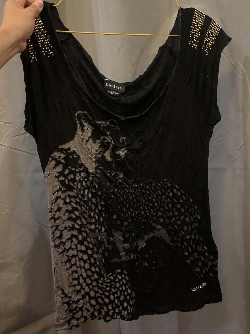 bebe Black Leopard Print Studded Shoulder Top (Category: Sleeveless) located in Malasiqui. Submitted by finnley26 (Listing ID 1468535967, Image 3). Description: - Brand: bebe - Size: Large - Color: Black with grey leopard graphic - Details: Gold studs on shoulders & small rhinestone logo near hem - Neckline: Wide scoop neck - Fabric: Soft, comfortable with crinkled texture throughout - Condition: Excellent, well-maintained.