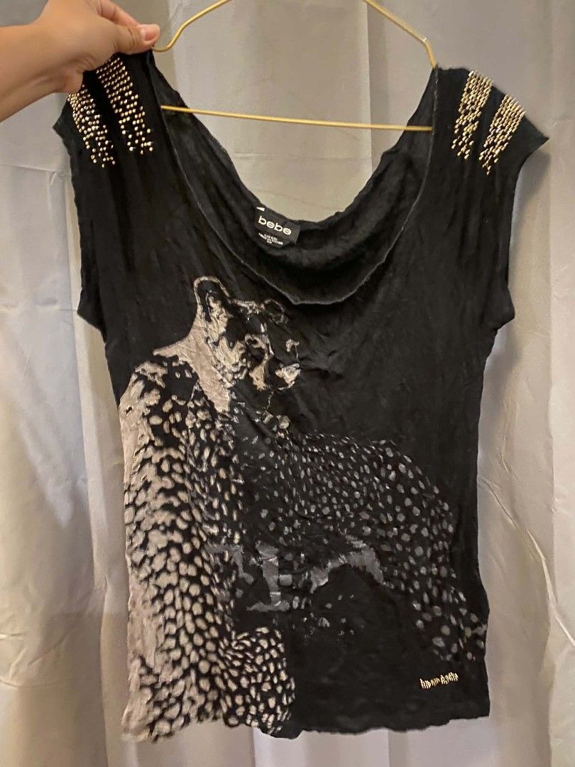 bebe Black Leopard Print Studded Shoulder Top (Category: Sleeveless) located in Malasiqui. Submitted by finnley26 (Listing ID 1468535967, Image 2). Description: - Brand: bebe - Size: Large - Color: Black with grey leopard graphic - Details: Gold studs on shoulders & small rhinestone logo near hem - Neckline: Wide scoop neck - Fabric: Soft, comfortable with crinkled texture throughout - Condition: Excellent, well-maintained.